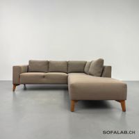 Ecksofa aus olivgrünem Stoff mit Holzfüssen