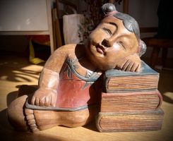 Holzschnitzerei / Figur: Schlafende Frau auf Bücherstapel