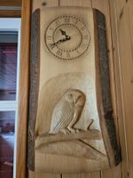 Handgeschnitzte Relief-Wanduhr auf einer Baumscheibe