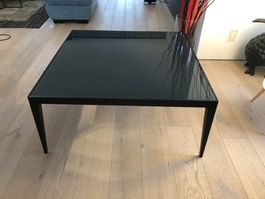 Dunkler Couchtisch mit schwarzem Glas. Elegant und praktisch