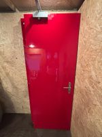 2 rote Holztüren mit WC-Symbolen