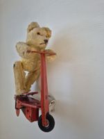 Teddybär auf rotem Roller Blechspielzeug