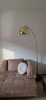 Bogenlampe goldfarben mit schwarzem Marmorfuss.