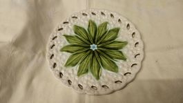 Vecchio piatto in ceramica bucherellato con fiore