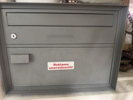 Briefkasten grau mit Schloss und Werbestop Aufkleber