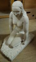 Statue en pierre jeune femme nue assise