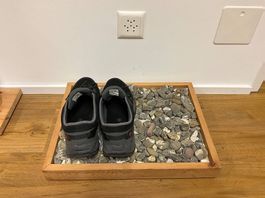 Schuhablage aus Arven-Holz mit Steinen