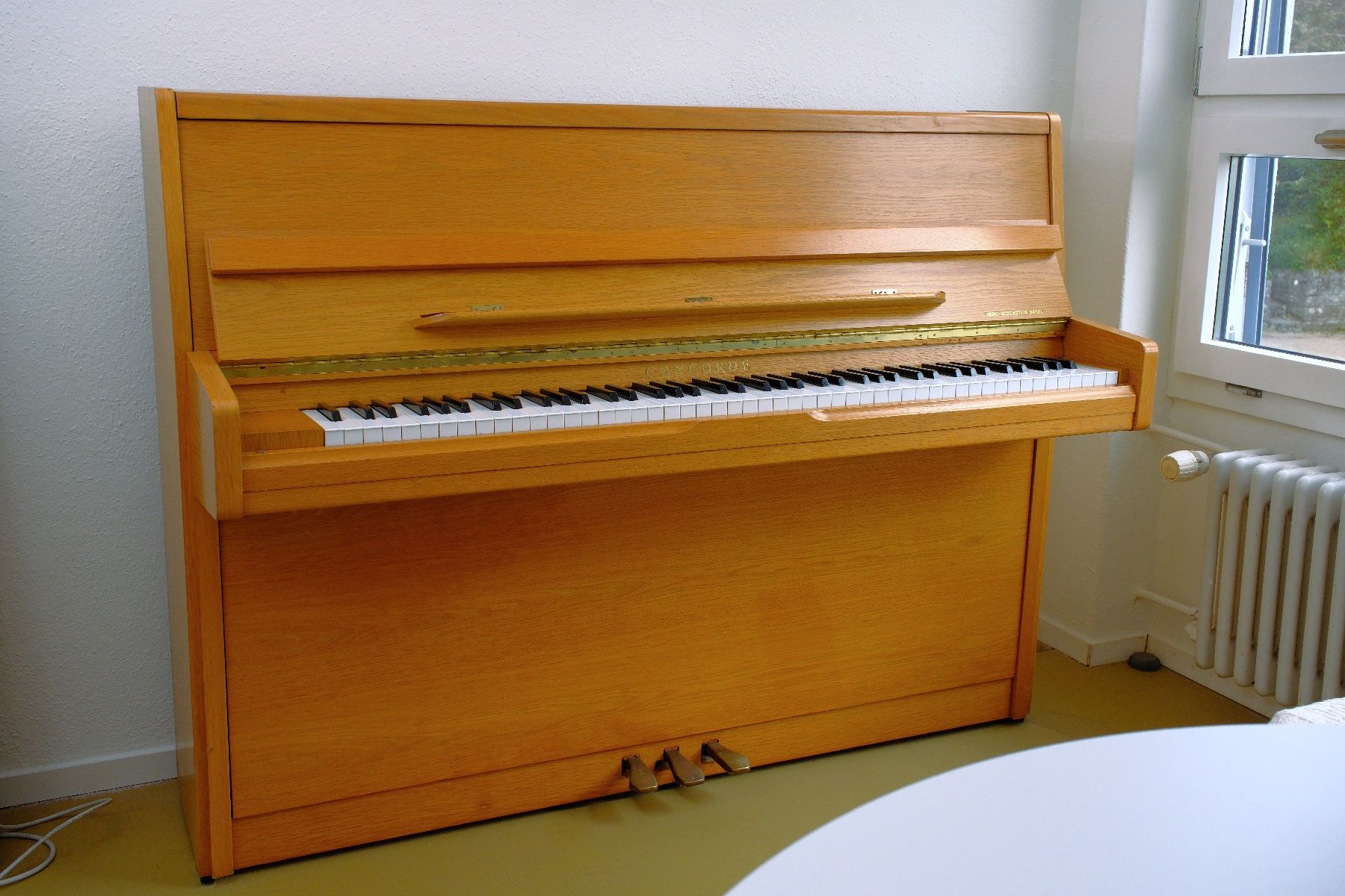 Concorde Strumenti musicali: Klavier Concorde (Eckenstein Basel), Eiche hell inkl. Hocker – Usato da Nussbaumen AG venduto da il_oui
