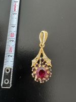 Goldener Modeschmuck Anhänger mit rotem Stein