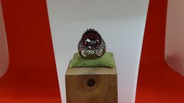 Ring mit grossem rotem Stein und Ziersteinen besetzt