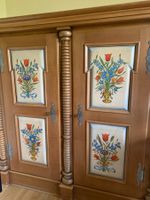 Solider Schrank mit Drechsleranteilen und Handmalerei.
