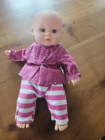 Süesse Babypuppe mit gestreifter Hose und Oberteil
