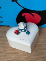 Weisses Schlumpfbaby auf Herzdose
