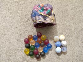 Sammlung bunte Glas Murmeln Kugeln schmuckes Stoff Säcklein