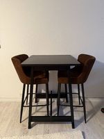 Bartisch mit zwei gepolsterten Barstühlen