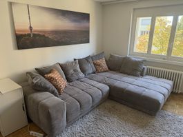 Ecksofa mit Schlaffunktion und Bettkasten grau