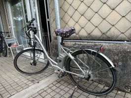 Altes „Flyer“-Elektrofahrrad mit einem Akku und Ladegerät
