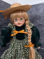 Porzellenpuppe mit Brille und Hut