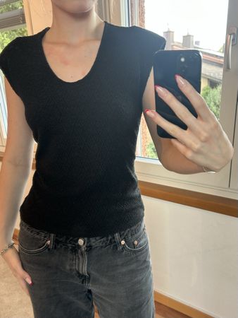 black V-neck top with shoulder pads  