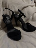 Sandales noires à talons aiguilles, élégantes et fines.