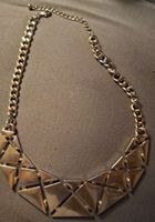 Collier couleur or avec motifs géométriques utilisé