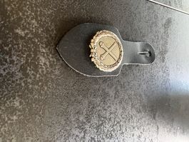 Anhänger mit Metall-Emblem und Lederband, neu