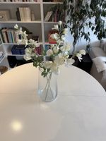 Vase en verre transparent avec fleurs blanches artificielles