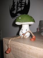 Cooler sitzender Pilz mit herabhängenden Beinen