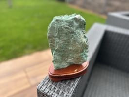 Dekorative grüne Edelstein Skulptur auf Holzsockel.