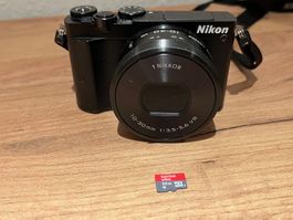 Nikon 1 J5 mit 2 Objektiven, 32 GB microSDcard, Tischstativ