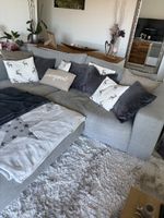 Sofa grau mit Hocker und Kissen gebrauchter Zustand