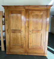 Antique kirschen two-door wooden wardrobe with visible damag