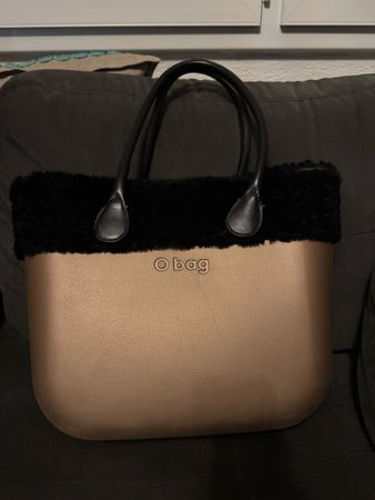 Sac O bag doré avec bordure en fausse fourrure noire.