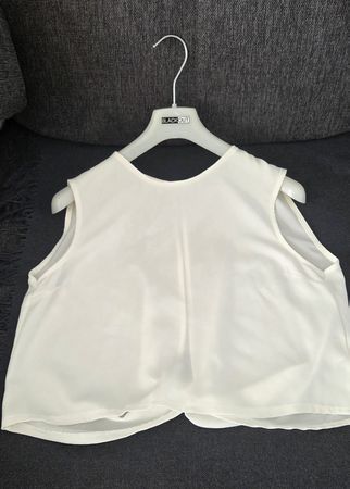  Einer eleganten, ärmellosen Bluse in der Farbe Off-White 