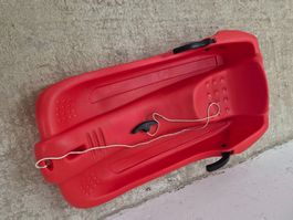 Luge en plastique rouge avec freins - bon état