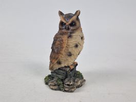 Dunkle Eulenfigur auf einem Stein