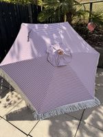 Schöner Sonnenschirm gestreift mit Fransen