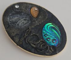 Broschen oval mit Schmucksteinen und Kettchen