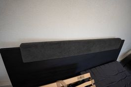 Dunkles Doppelbett mit Kopfpolster inkl. Lattenrosten