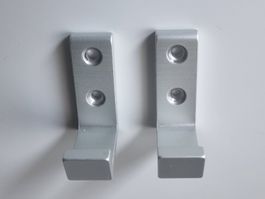 2 crochets muraux en aluminium, hauteur 4,5, prof. 3.5 cm.