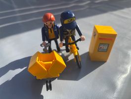 2 Playmobil Postboten mit Fahrrad und Briefkasten.