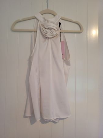 Top panna elegante con fiore, taglia S, perfetto per l'estat