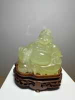 lachender Buddha aus Stein geschnitzt mit Holzsockel