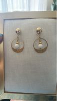 Gold tone hoop earrings with white bead