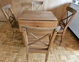 Hochwertiger Esstisch aus Holz mit vier Holzstühlen.