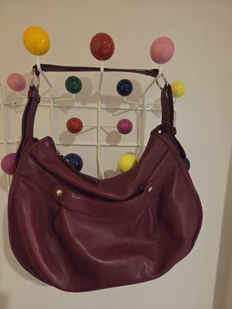 Schöne, bordeauxrote Handtasche von Coccinelle aus Leder.