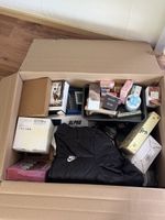 Diverse Box mit Kleidung und Kosmetik