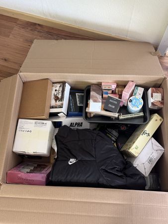 Diverse Box mit Kleidung und Kosmetik