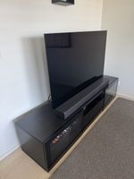 meuble TV IKEA BESTÅ en brun-noir, avec des portes vitrées 