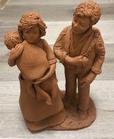 Tonskulptur einer Familie mit Arbeitsschürze Kind in Decke
